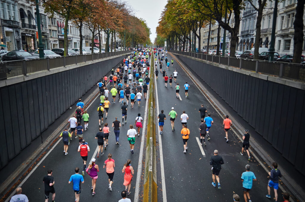 group of runners moving down a four lane highway 