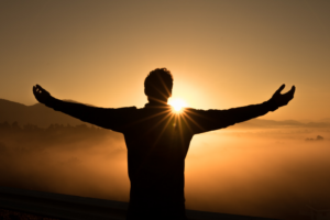 man facing the sunrise